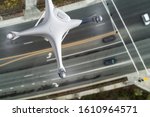 Unmanned Aircraft System Quadcopter Drone In The Air Over Roadway with Automobiles.