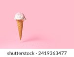 Small photo of summer funny creative concept of flying wafer cone with ice cream and strewed sprinkles on pink background