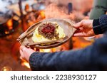 Small photo of Traditional finnish food sauteed reindeer with mashed potatoes and lingonberries served in lappish hut next to open fire