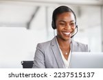 Smiling african american customer care representative working with headset in office. Black woman telemarketing agent working in call center. Call center agent with headset makinga video call.
