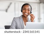 Portrait of smiling african american customer care service with headset attending calls in office. Black mature telemarketing agent working in call center and looking at camera with copy space. 
