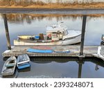 Small photo of Old fishing boat and row boat skiffs show many years of use, Saugus river dock Massachusetts USA, November 25 2023