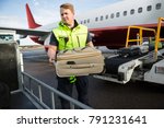 Worker Placing Luggage In...