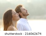 Profile of a couple of man and woman breathing deep fresh air together at sunset               