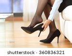 Businesswoman taking off high heels shoes after work at home