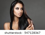 Portrait attractive brunette on a gray background. Beautiful dark hair. Girl looking away