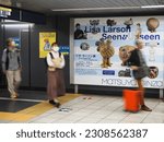Small photo of TOKYO, JAPAN - May 25, 2023: People pass an advert in a Tokyo Metro subway station for a Lisa Larson exhibition at Matsuya Ginza Department Store.