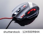 a sleek modern gaming mouse with red buttons over a dark shiny surface