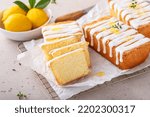 Small photo of Classic lemon pound cake with powdered sugar glaze sliced on parchment paper topped with lemon zest