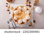 Pumpkin cheesecake swirl pie topped with whipped cream on a marble board, original Thanksgiving dessert idea