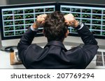 Stock trader tearing out his hair from despair, rear view