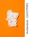Small photo of A swatch of cream or face mask. The appearance of the texture of the cream on orange background. Skincare products, natural cosmetic. Beauty concept for face and body care