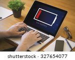 Businessman at work. Close-up top view of man working on laptop with low battery. all screen graphics are made up.