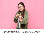 Small photo of asian young woman feeling disgusted and nauseous, backing away from something nasty, smelly or stinky, saying yuck