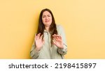 Small photo of pretty caucasian woman feeling disgusted and nauseous, backing away from something nasty, smelly or stinky, saying yuck