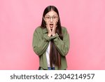 Small photo of asian young woman feeling shocked and scared, looking terrified with open mouth and hands on cheeks