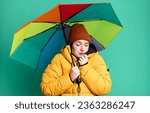 Small photo of young pretty woman wearing an anorak and a umbrella