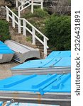 Small photo of Small blue-covered fishing boats ashore at the foot of a brick and concrete flight of stairs going up from Ben Buckler Point area to Ramsgate Avenue on North Bondi Beach. Sydney-NSW-Australia.