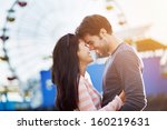 romantic couple embracing with santa monica pier in background