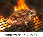 beef steak cooking over flaming grill