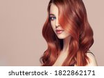 Beauty redhead girl with long  and   shiny wavy red hair .  Beautiful   woman model with curly hairstyle .
