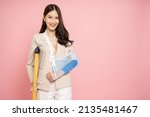 Small photo of Young Asian businesswoman put on a soft splint due to a broken arm isolated on pink background, Personal accident concept