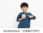Small photo of Portrait of happy Asian little boy holding sky blue piggy bank isolated on white background, Saving money and financial economize concept