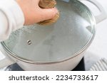 Boiling water in a large cooking pot to prepare linguine pasta.