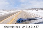 Small photo of Navigating a frontage road post-winter storm offers a serene drive. The surrounding landscape, blanketed in snow, contributes to the peaceful and picturesque environment, enhancing the driving