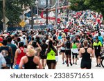 Small photo of Atlanta, GA USA - July 4, 2023: Thousands of runners plod toward the finish line of the Peachtree Road Race on July 4, 2023 in Atlanta, GA.