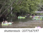 Small photo of Helen, GA USA - September 9, 2023: Telephoto view shows people tubing on the Chattahoochee River on a hot summer day on September 9, 2023 in Helen, GA.
