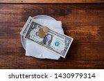 Small photo of Restaurant tips or gratuity. Banknotes and coins on a plate