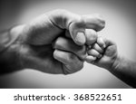 Fist Of Dad And Newborn Baby