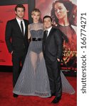 Small photo of LOS ANGELES, CA - NOVEMBER 18, 2013: Jennifer Lawrence with Liam Hemsworth (left) & Josh Hutcherson at the US premiere of their movie "The Hunger Games: Catching Fire" at the Nokia Theatre LA Live.