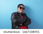 Fat rich Asian boy smiling at camera with proud, boy wearing black leather jacket and sunglasses