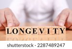 Small photo of Longevity, text words typography written with wooden letter, life and business motivational inspirational concept