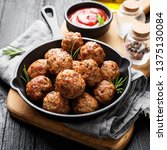 Meatballs served with tomato sauce in frying pan .