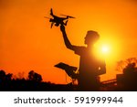 silhouette of the man holding Drone in sunset