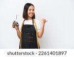 Young seamstress woman isolated on white background pointing to the side to present a product