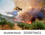 Small photo of Peloponnese, Greece, 05 August 2021: A firefighting plane releases its load of water as it tries to extinguish a fire in Xelidoni village in the area of Ancient Olympia