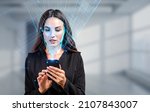 Small photo of Businesswoman with phone in hands, biometric verification and face detection. Unlocking smartphone with facial scanner. Concept of face id and high tech technology