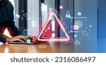 Small photo of Businessman hands typing on laptop with triangular malware caution warning sign. Virus scam phishing cyber crime concept. Password hacking