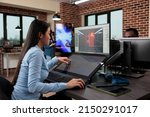 Small photo of Creative company game developer sitting in production department while developing 3D videogames scenes and environment. Asian employee working on level design using modern software.