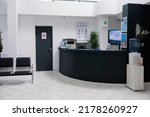 Nobody in waiting room with front desk reception and wall screen tv with promotional offer in private practice hopital. Waiting area for patients with doctor appointments in modern healthcare clinic.