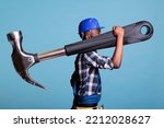Small photo of Concept of heavy work, African american builder with giant hammer in studio shot. Strong man heavy work Construction worker carrying huge work tool wearing coveralls and hard hat, construction