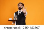Small photo of Expert valet posing with meal tray and showcasing stop signal with his palm. Staff of luxury restaurant becoming dissatisfied and rejecting other ideas, declining to comply with them.