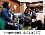 Tired African American guy in wheelchair arriving at luxury resort with wife, hotel guest with disability access needs waiting for check-in. Facilities for disabled tourists in hospitality industry