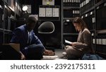 Small photo of In well-equipped room, multiethnic team of private detectives conduct thorough investigations. Two investigators gather case information, examining witness testimonies, and doing research with laptop.