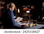 Small photo of Experienced suitmaker checking tailoring materials price list before starting customer comission in atelier shop studio. Elderly fashion designer checking sartorial outfit sketch drawing