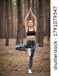 Small photo of Beautiful woman standing and doing yoga in forest. Exercise and meditation concept. Pay obeisance or raise hand concept. Pine wood in summer theme. Back view.